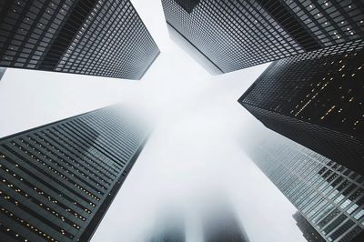 low-angle shot skyscrapers foggy day. poster
