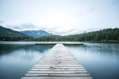 long wooden pier smooth lake.