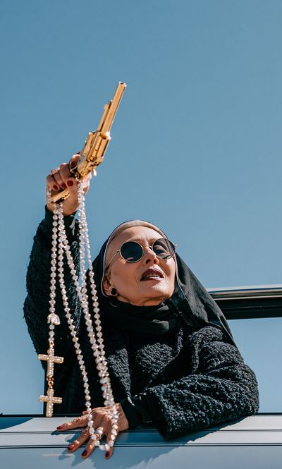 Nun with Gold Gun Photography Poster. poster print