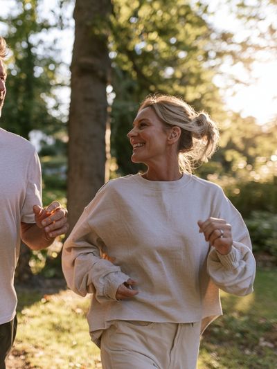 Couple Jogging in Sunlit Forest Photography Poster.