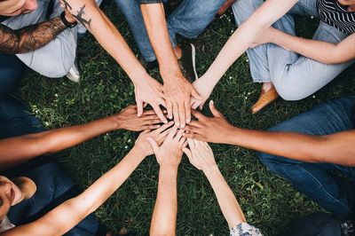 People stacking hands together park.