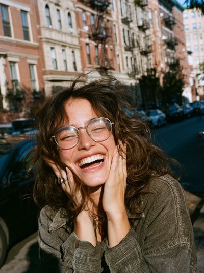 Smiling Woman in City Street Poster. poster