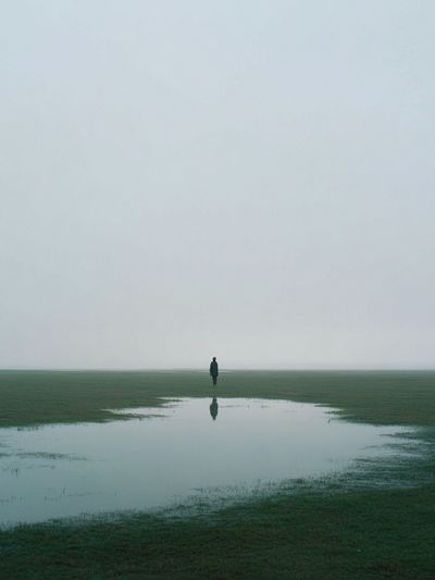 Lone Figure in Misty Field Poster. poster print