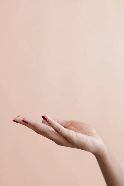Female hand beige background.