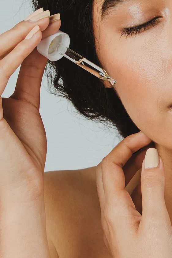 Young woman applying serum her. poster — photography art